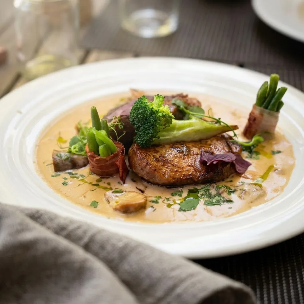 Gebratenes Fleisch mit Röstgemüse in Rahmsauce